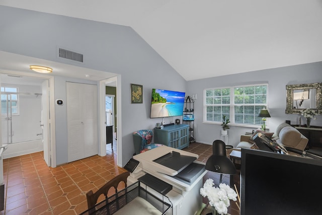 living room with lofted ceiling, plenty of natural light, and tile patterned floors