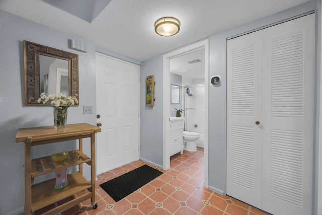 foyer entrance featuring tile patterned flooring and a textured ceiling