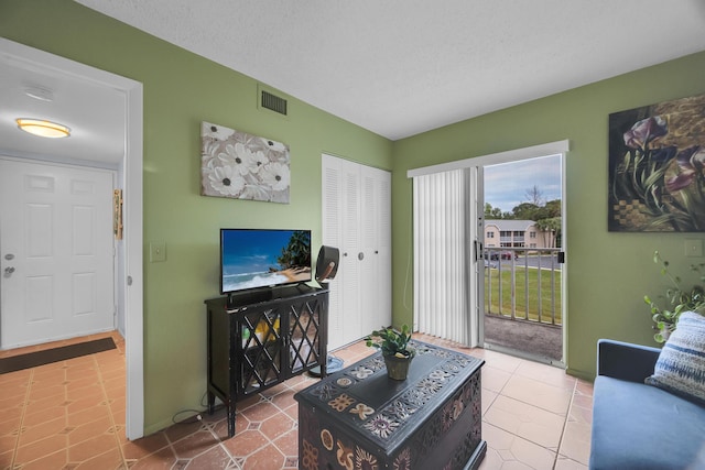 living room featuring a textured ceiling and tile patterned flooring