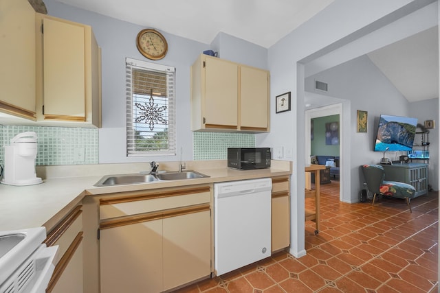 kitchen with stove, white dishwasher, tile patterned floors, vaulted ceiling, and cream cabinets