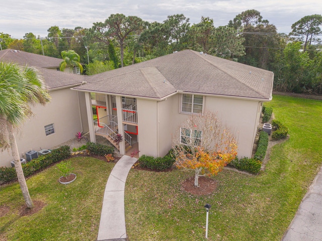 view of front of house with a front yard and central AC