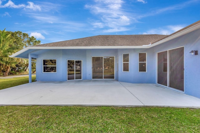 rear view of property featuring a yard and a patio area