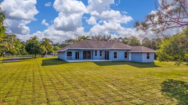 back of property featuring a lawn and a patio