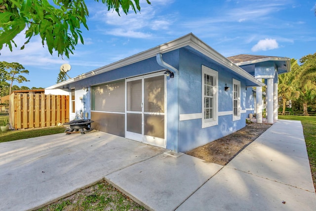 12855 87th St N, West Palm Beach, FL 33412 - view of side of property with stucco siding, fence, and a patio