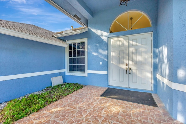 12855 87th St N, West Palm Beach, FL 33412 - doorway to property with stucco siding and a shingled roof