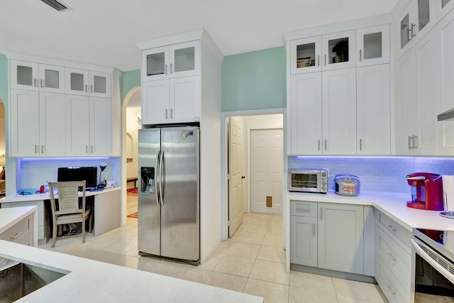 kitchen featuring white cabinetry, decorative backsplash, stainless steel appliances, and light tile patterned flooring