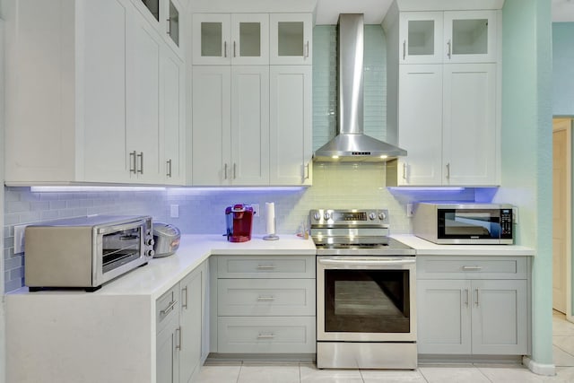 12855 87th St N, West Palm Beach, FL 33412 - kitchen with appliances with stainless steel finishes, wall chimney exhaust hood, light countertops, and decorative backsplash