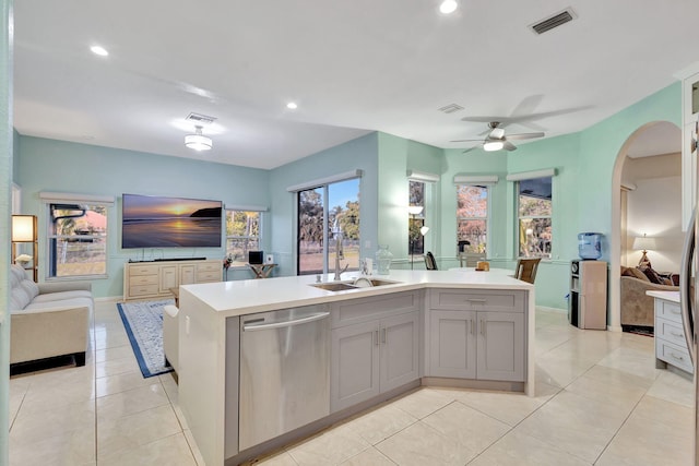 kitchen with sink, gray cabinetry, a center island with sink, light tile patterned floors, and stainless steel dishwasher