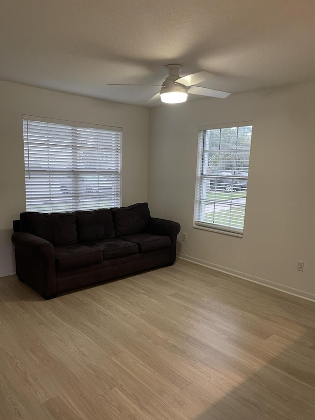 living room with light wood-type flooring and ceiling fan