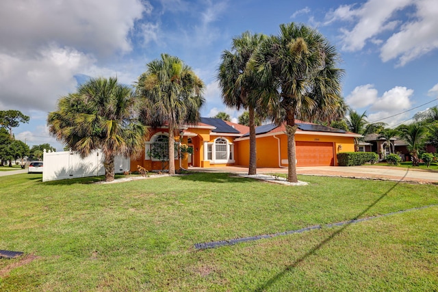 view of front of house featuring a garage, a front yard, and solar panels