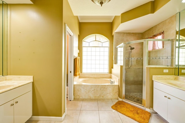 bathroom with tile patterned flooring, plus walk in shower, a healthy amount of sunlight, and vanity