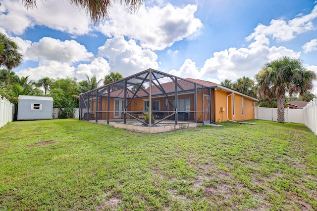 back of property featuring a lanai, a storage unit, and a lawn