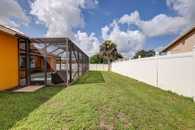 view of yard featuring a fenced in pool and glass enclosure