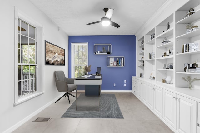 office with a textured ceiling, ceiling fan, a wealth of natural light, and built in shelves