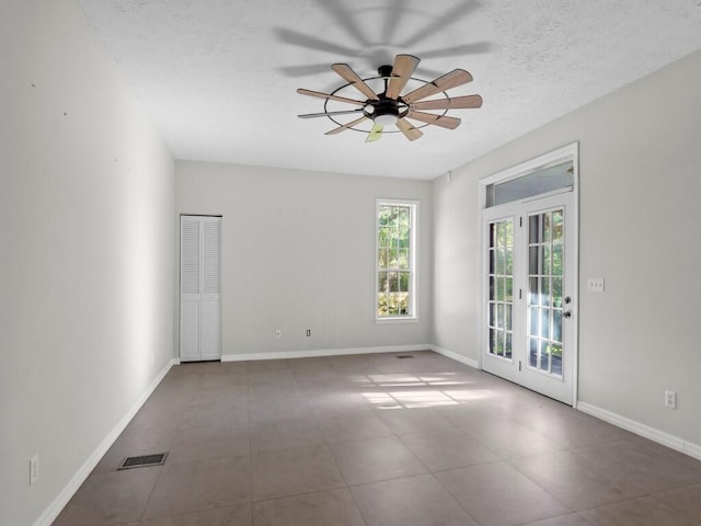 spare room with ceiling fan, french doors, and a textured ceiling