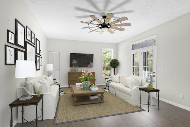 living room with ceiling fan, french doors, and a textured ceiling