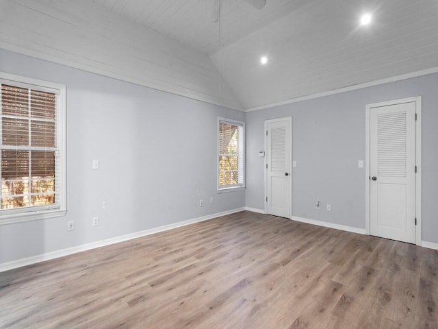 spare room with lofted ceiling and light hardwood / wood-style floors