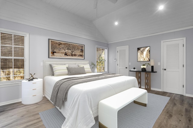 bedroom featuring ceiling fan, lofted ceiling, hardwood / wood-style flooring, and multiple windows