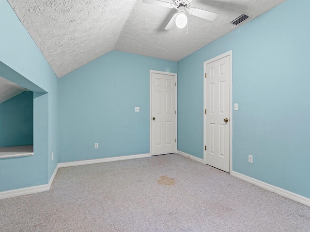 bonus room with a textured ceiling, lofted ceiling, and light colored carpet