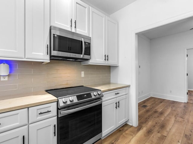 kitchen featuring appliances with stainless steel finishes, decorative backsplash, light hardwood / wood-style floors, and white cabinetry