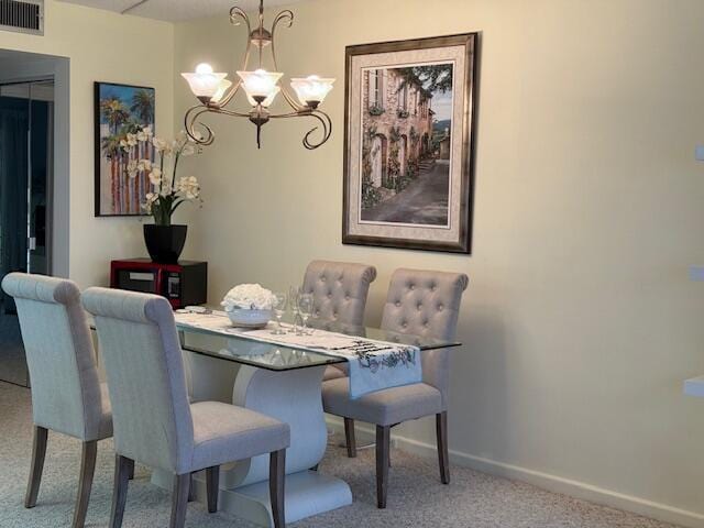 dining space with a notable chandelier and carpet floors