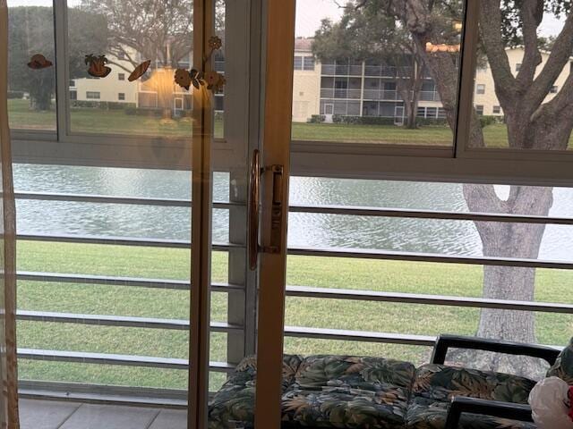 doorway with tile patterned flooring and a water view