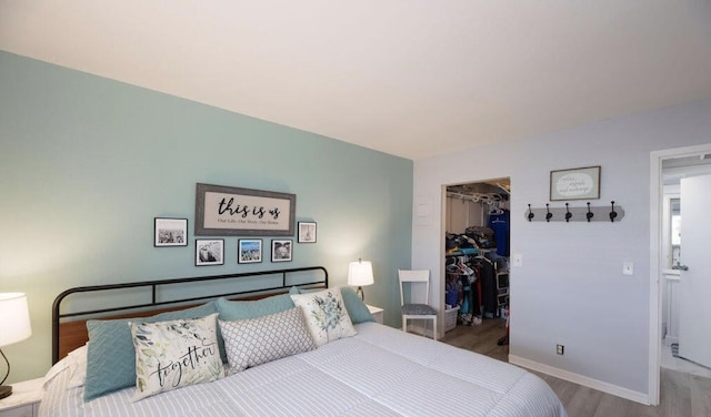 bedroom featuring a closet, a walk in closet, and hardwood / wood-style floors