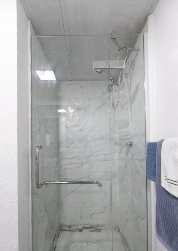 bathroom featuring a shower with door