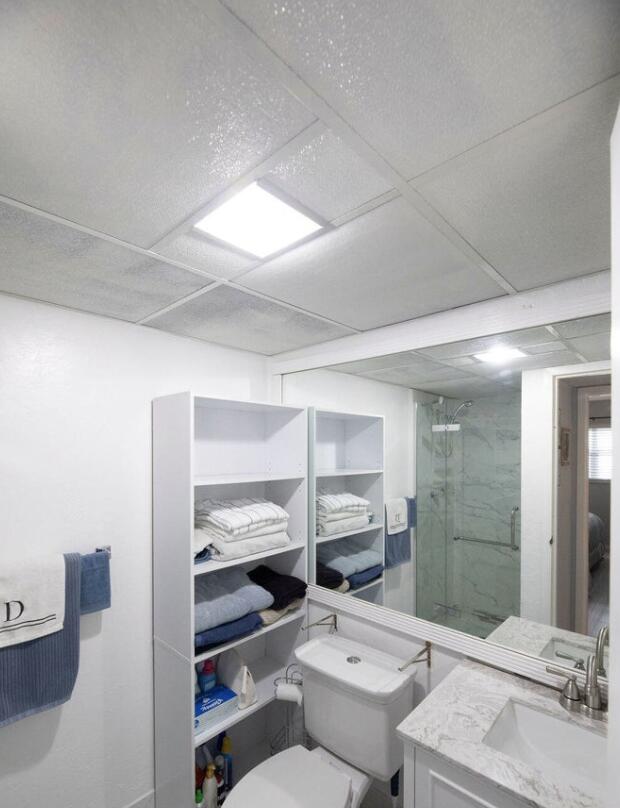 bathroom featuring a drop ceiling, an enclosed shower, vanity, and toilet