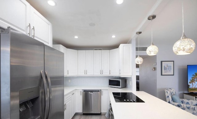 kitchen with white cabinets, backsplash, appliances with stainless steel finishes, and pendant lighting