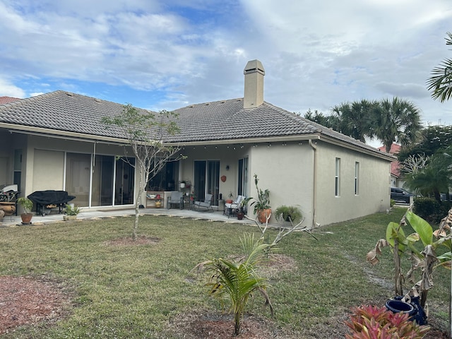 rear view of house featuring a yard and a patio