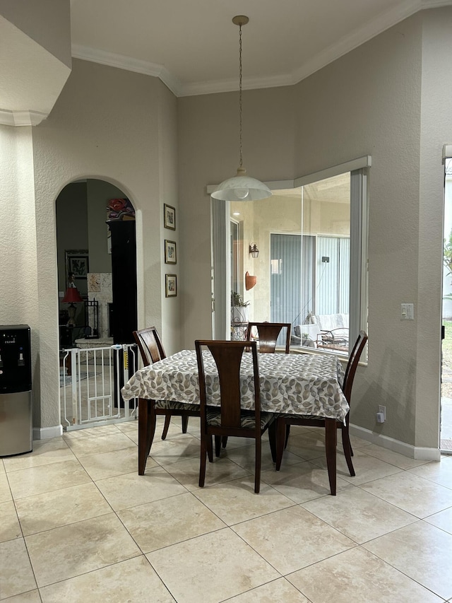 dining area with ornamental molding and light tile patterned flooring