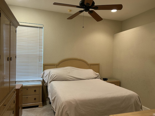 tiled bedroom featuring ceiling fan