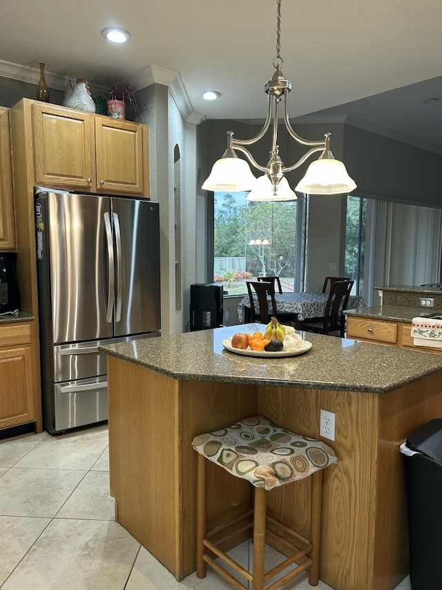 kitchen featuring pendant lighting, stainless steel fridge, a chandelier, a breakfast bar, and light tile patterned floors