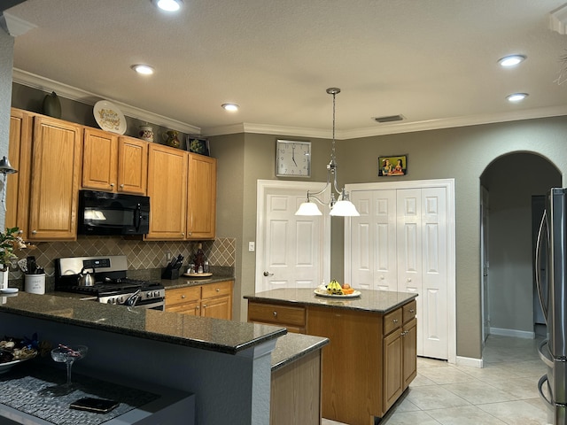 kitchen featuring backsplash, a kitchen island, hanging light fixtures, stainless steel appliances, and light tile patterned floors