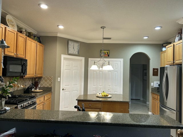 kitchen featuring appliances with stainless steel finishes, a kitchen island, backsplash, ornamental molding, and a chandelier