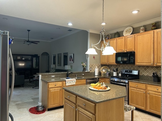 kitchen with appliances with stainless steel finishes, a center island, sink, backsplash, and ceiling fan