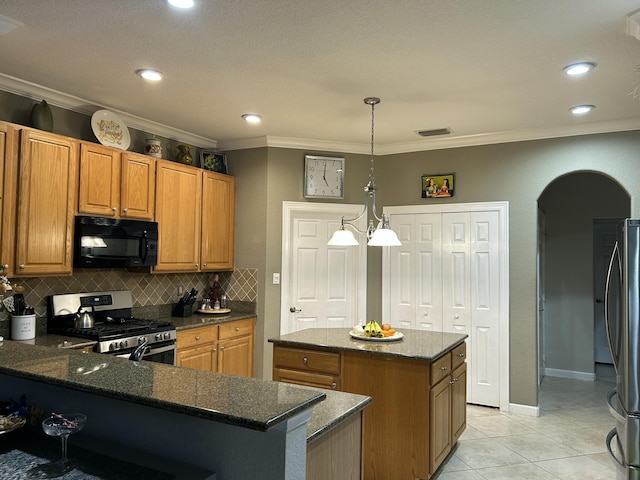 kitchen featuring pendant lighting, a center island, stainless steel appliances, dark stone counters, and light tile patterned flooring