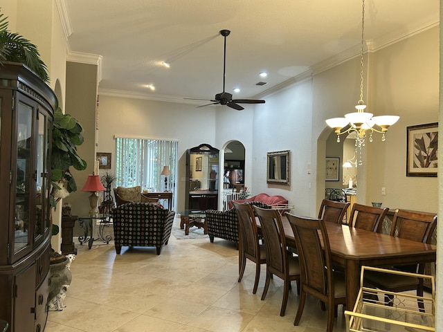 dining room featuring ceiling fan with notable chandelier, light tile patterned floors, ornamental molding, and a towering ceiling