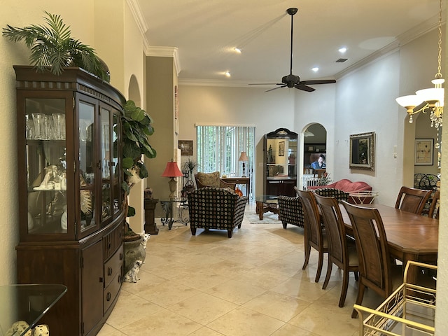 tiled dining space featuring ceiling fan and ornamental molding