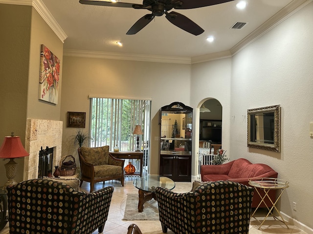 sitting room with a fireplace, light tile patterned floors, ornamental molding, and ceiling fan