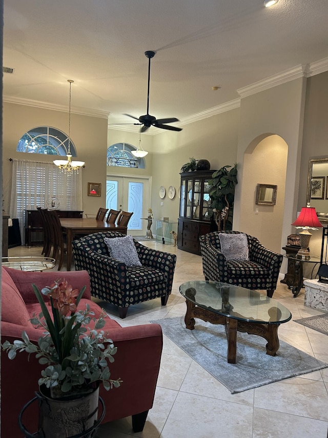 living room featuring ceiling fan with notable chandelier, light tile patterned floors, ornamental molding, and french doors