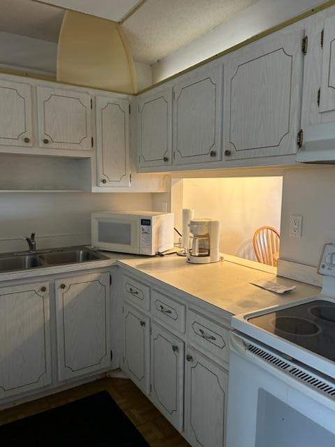 kitchen with sink, white range with electric stovetop, and white cabinets