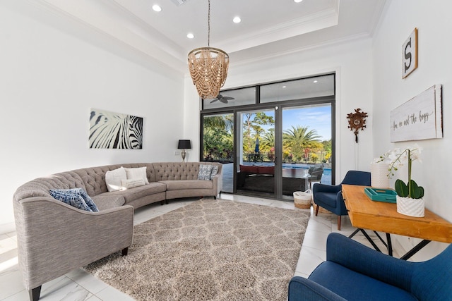 living room featuring an inviting chandelier, ornamental molding, and a raised ceiling