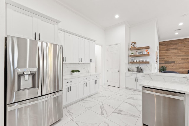 kitchen featuring white cabinetry, stainless steel appliances, light stone counters, and backsplash