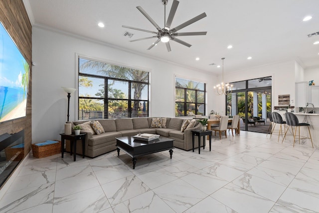 living room featuring crown molding, sink, and ceiling fan with notable chandelier