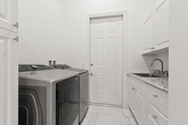 laundry area featuring cabinets, washing machine and clothes dryer, and sink