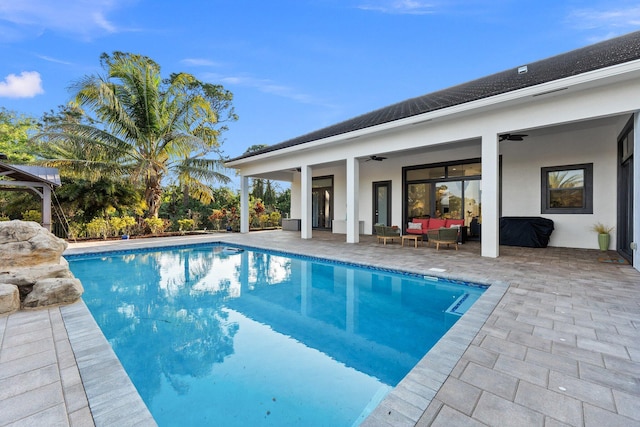 view of swimming pool featuring a patio area, outdoor lounge area, and ceiling fan