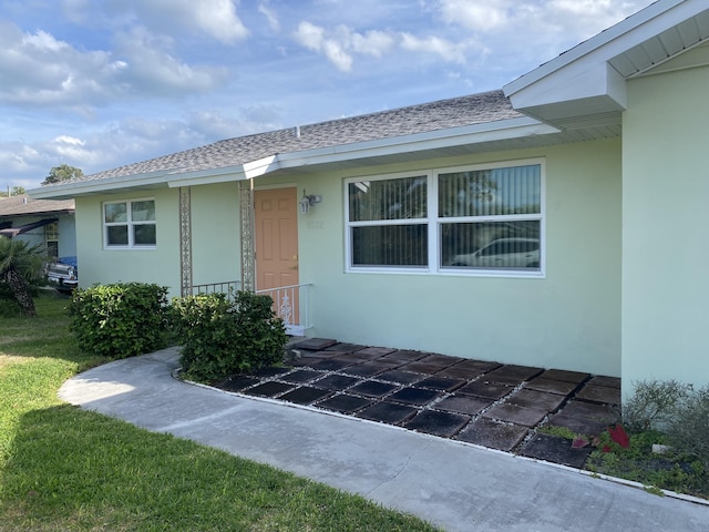 property entrance with a lawn