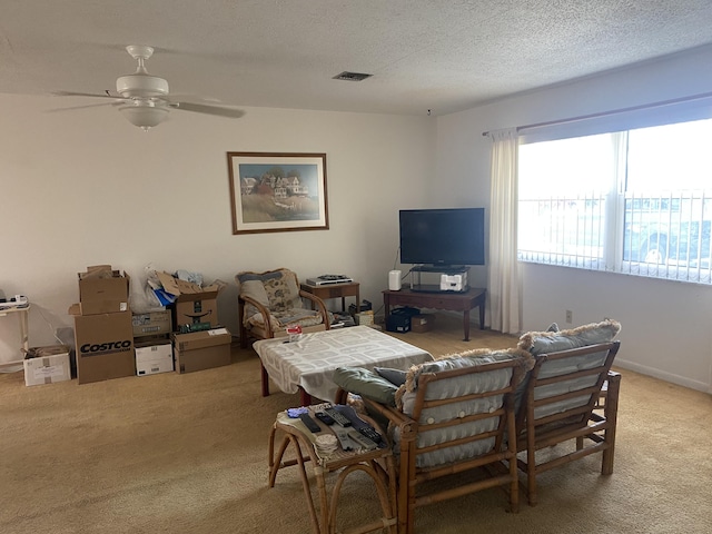 living room with ceiling fan, a textured ceiling, and carpet flooring